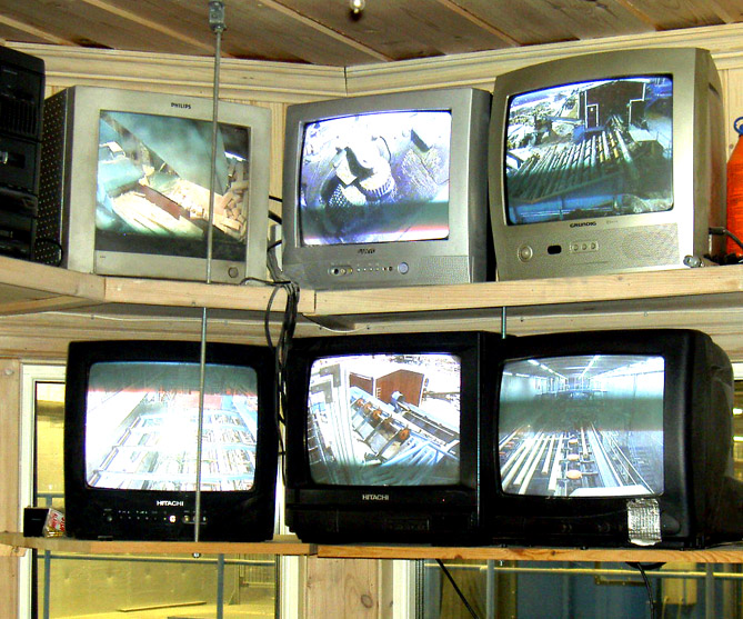 i de sex monitorerna, där man kan se stockarna komma ut från barkningen och steg för steg åka vidare i förädlingen