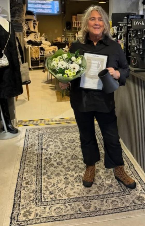 En glad Mia har återvänt med blomor och diplom till<br />modebruket - kollegan fotograferade.