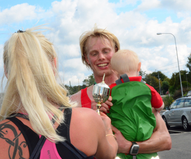 Erk Wickström tog emot vinnarpokalen med sitt lilla barn på armen.