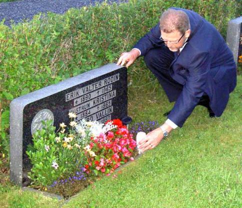 Christer tnder ett minnesljus p Edvard Wallins grav.