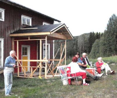 Sten Hansson, Arvid Westin och Anna-Lisa Nordlf sitter framfr den veranda som r p gng p det andra huset vid Finnprtet