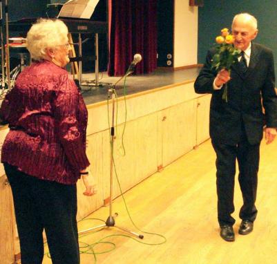 Gull-Maj förärar Göte Nordlöf med rosor för hans trogna medverkan i pensionärsföreningen under alla år