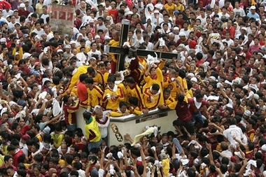 Thousands of Filipino devotees take part in a procession marking the 400th anniversary of the Feast of the Black Nazarene in Manila January 9, 2007. Devotees struggle to get close to the Black Nazarene carrying the wooden cross as it is believed that wiping a piece of cloth on it or just touching it can bring miracles or good luck. 