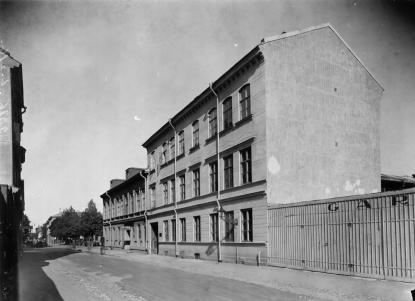 Bertil Nordholm bodde nära skolan i det bortre av husen på Norra Slottsgatan. Där infarten till Flanörs parkeringshus finns. I bakgrunden kan träden på Vasaskolans gård ses.