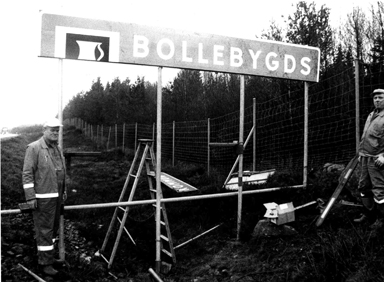 i slutet av december 1994 jobbades det med att sätta upp nya kommunskyltar runt om Bollebygd. Här är det ett par män från dåvarande Vägverket som sätter upp den nya kommunskylten på R40.
